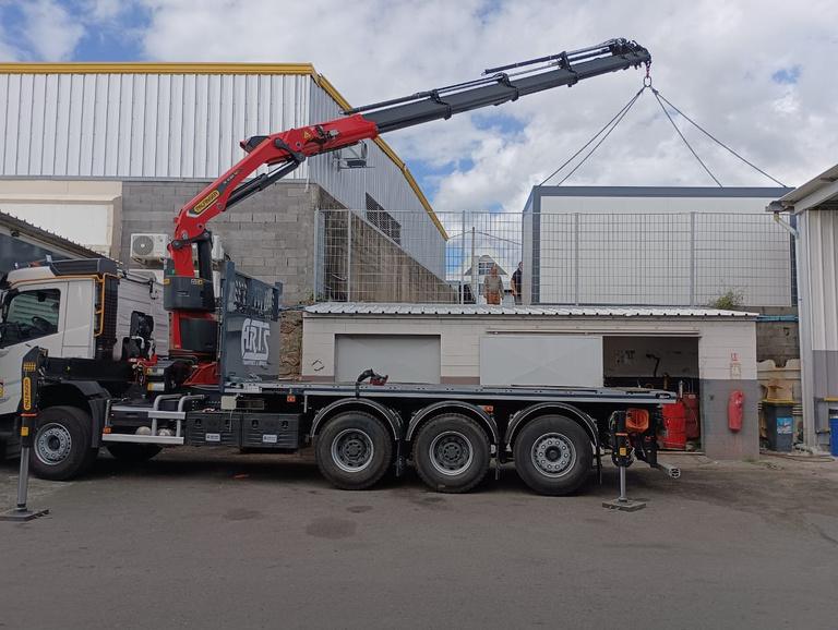 Camion grue à bras articulé levant une charge