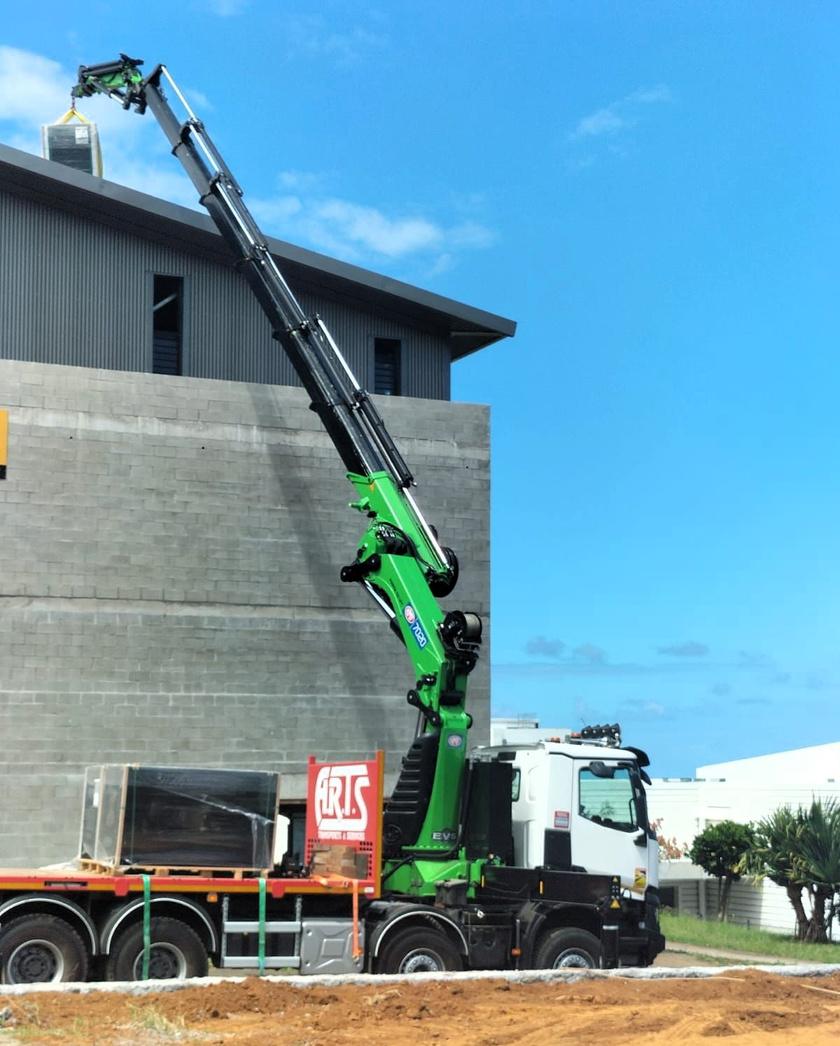 Camion grue ARTS posant des vitrages sur un bâtiment