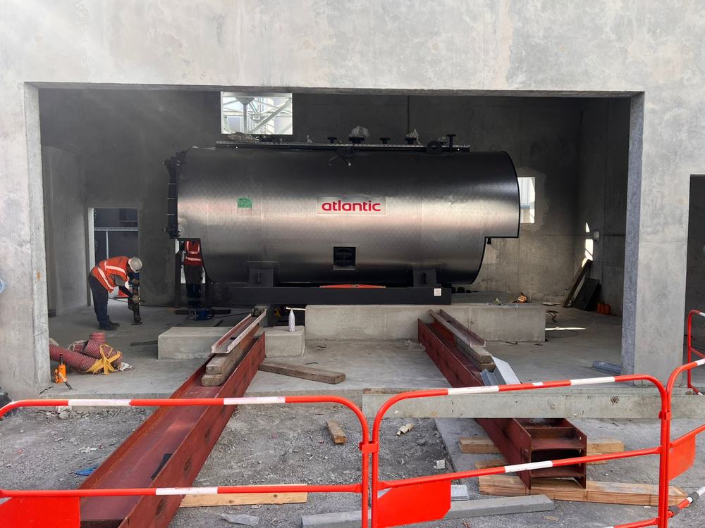 Chaudière industrielle mise en place sur rails de ripage dans un local béton