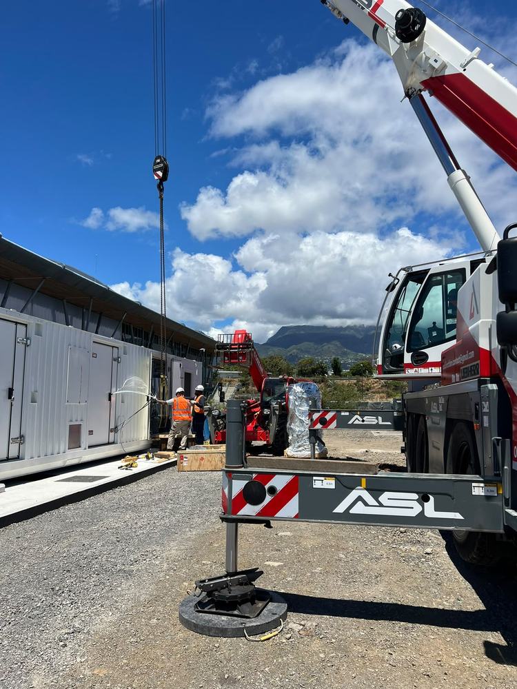 Grue ASL introduisant un équipement dans un conteneur technique