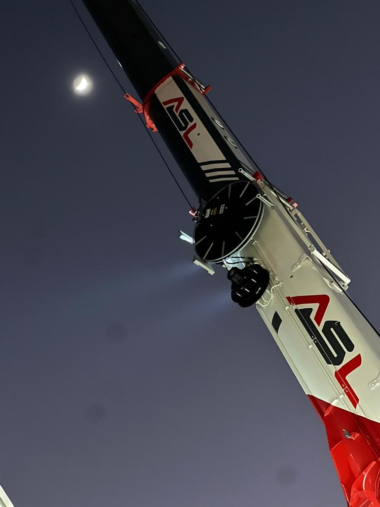 Flèche d’une grue ASL déployée de nuit sous la lune