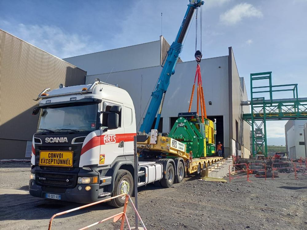 Grue ASL déchargeant une machine industrielle de 42 t d’un convoi ARTS devant une usine